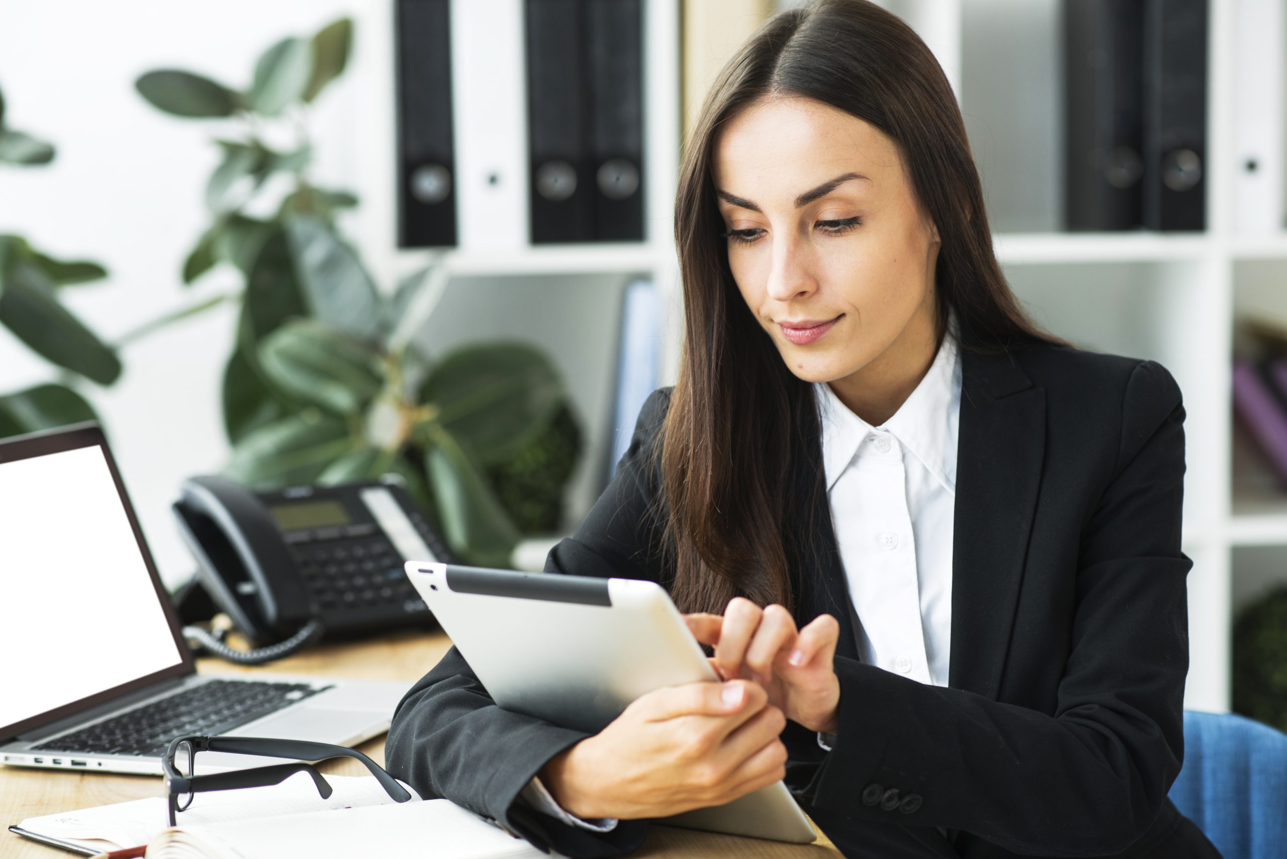 empresaria-joven-sonriente-que-usa-la-tableta-digital-en-la-oficina (1)